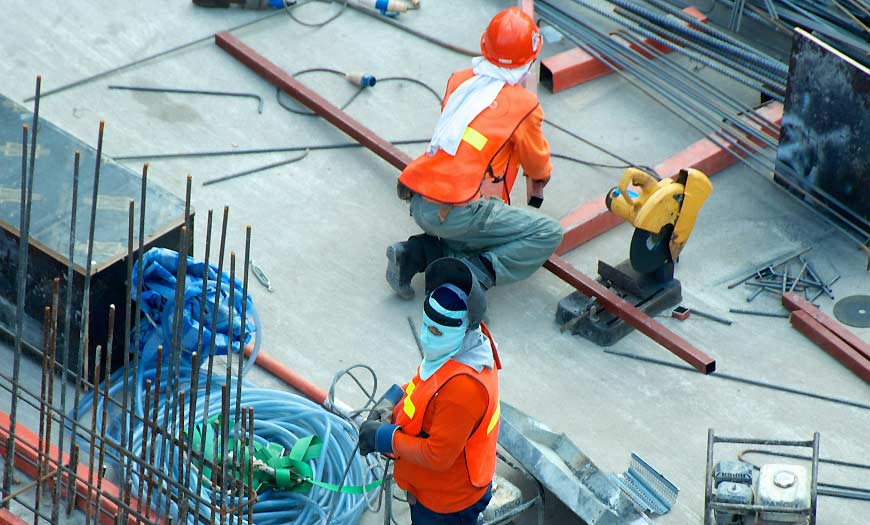 Two Men Working in a Factory Persones treballant en una fàbrica que ofereix solucions tècniques eficients.